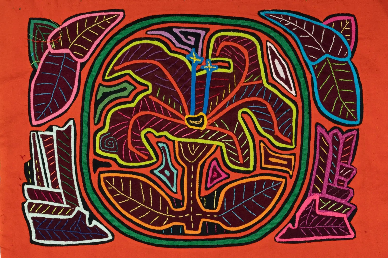 Colorful hand-stitched tapestry featuring a shaggy puppy with flowers and leaves on a vibrant orange background.