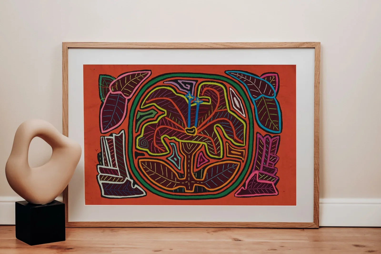 Colorful shaggy puppy design surrounded by vibrant leaves on a warm background, showcasing traditional handmade Mola art.
