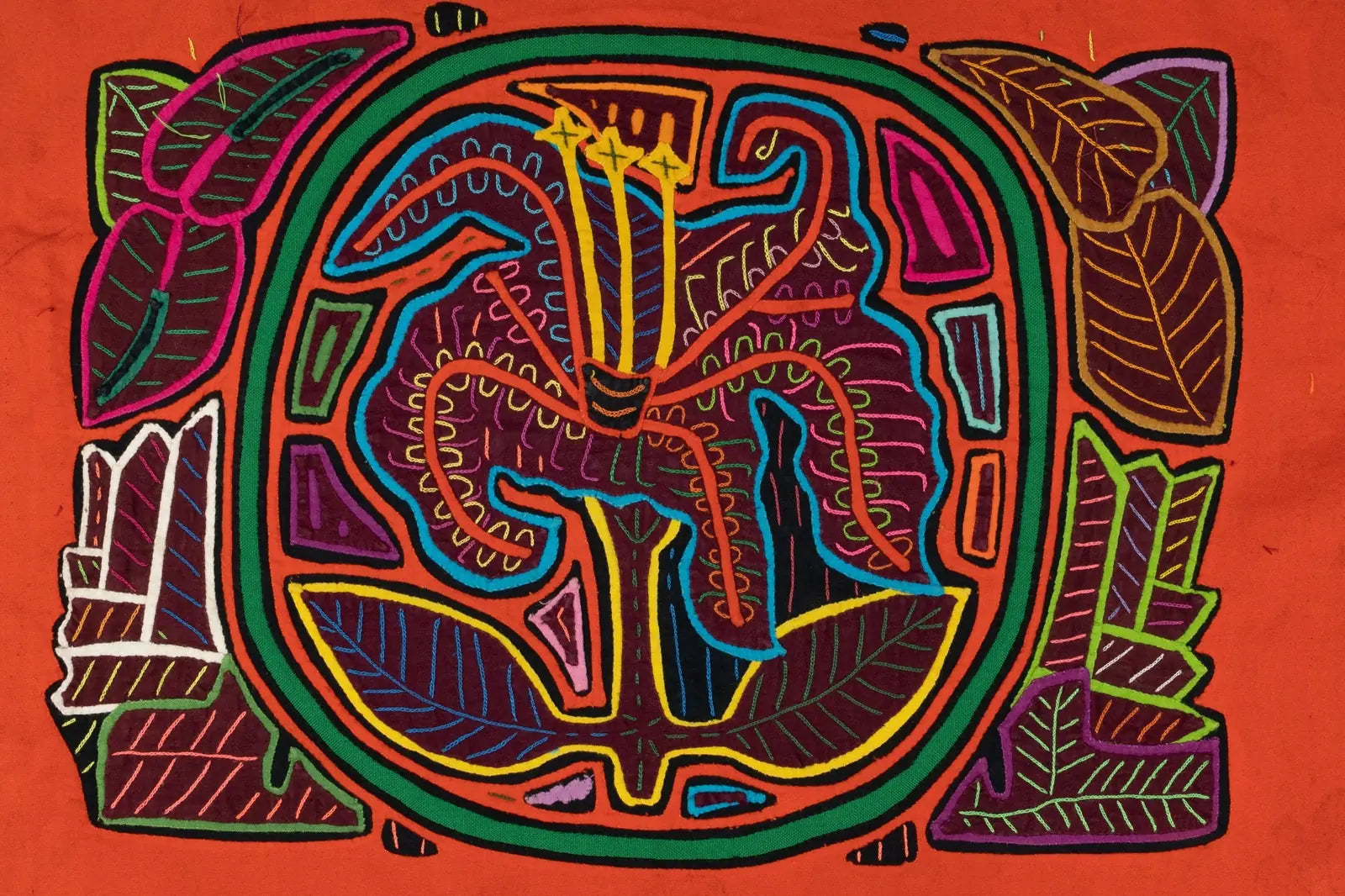 Colorful textile art featuring a shaggy puppy with a flower, hand-stitched in a vibrant Mola design on an orange background.