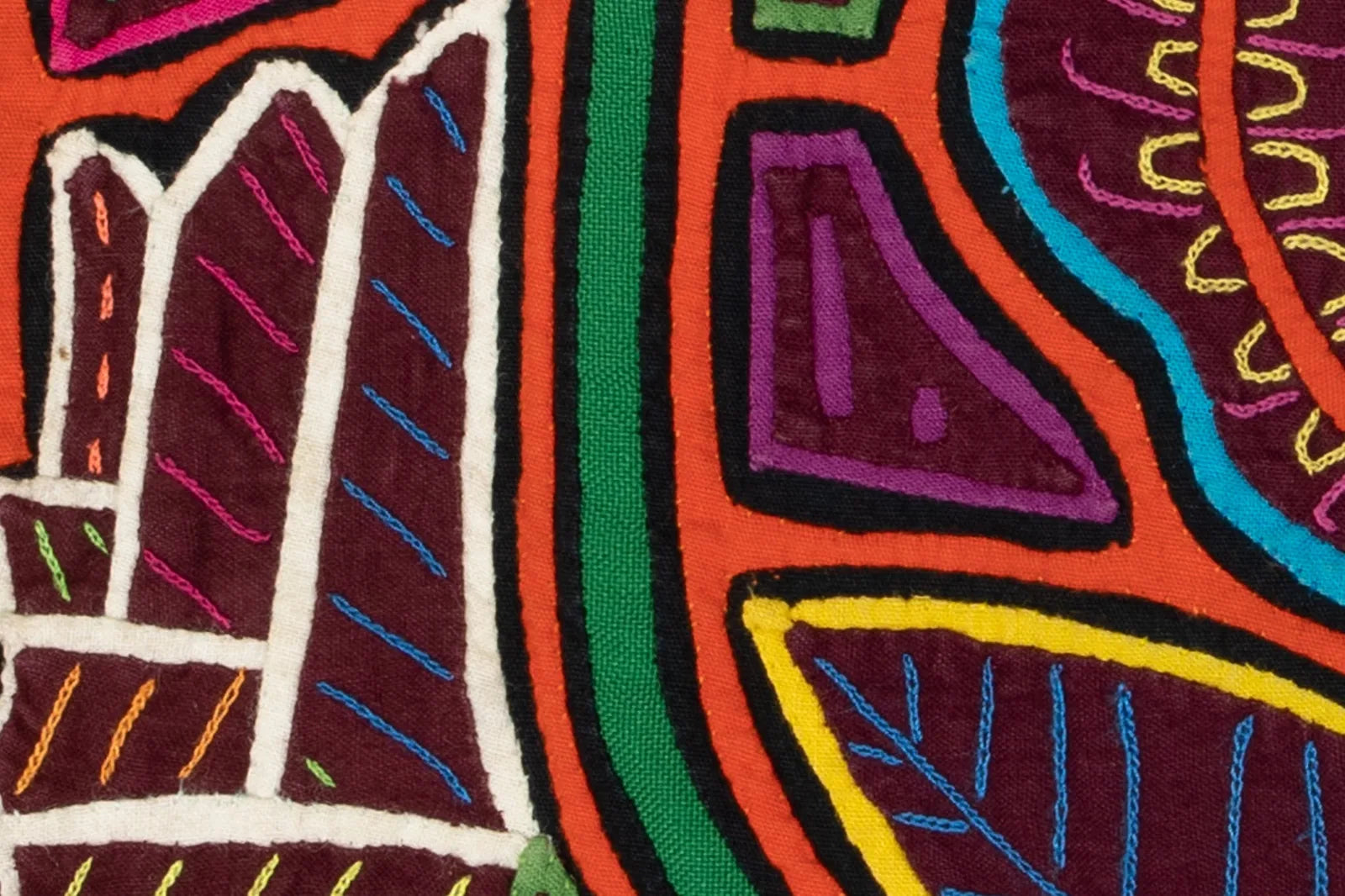 Colorful hand-stitched textile art featuring a shaggy puppy dog and flowers, showcasing intricate reverse appliqué design.