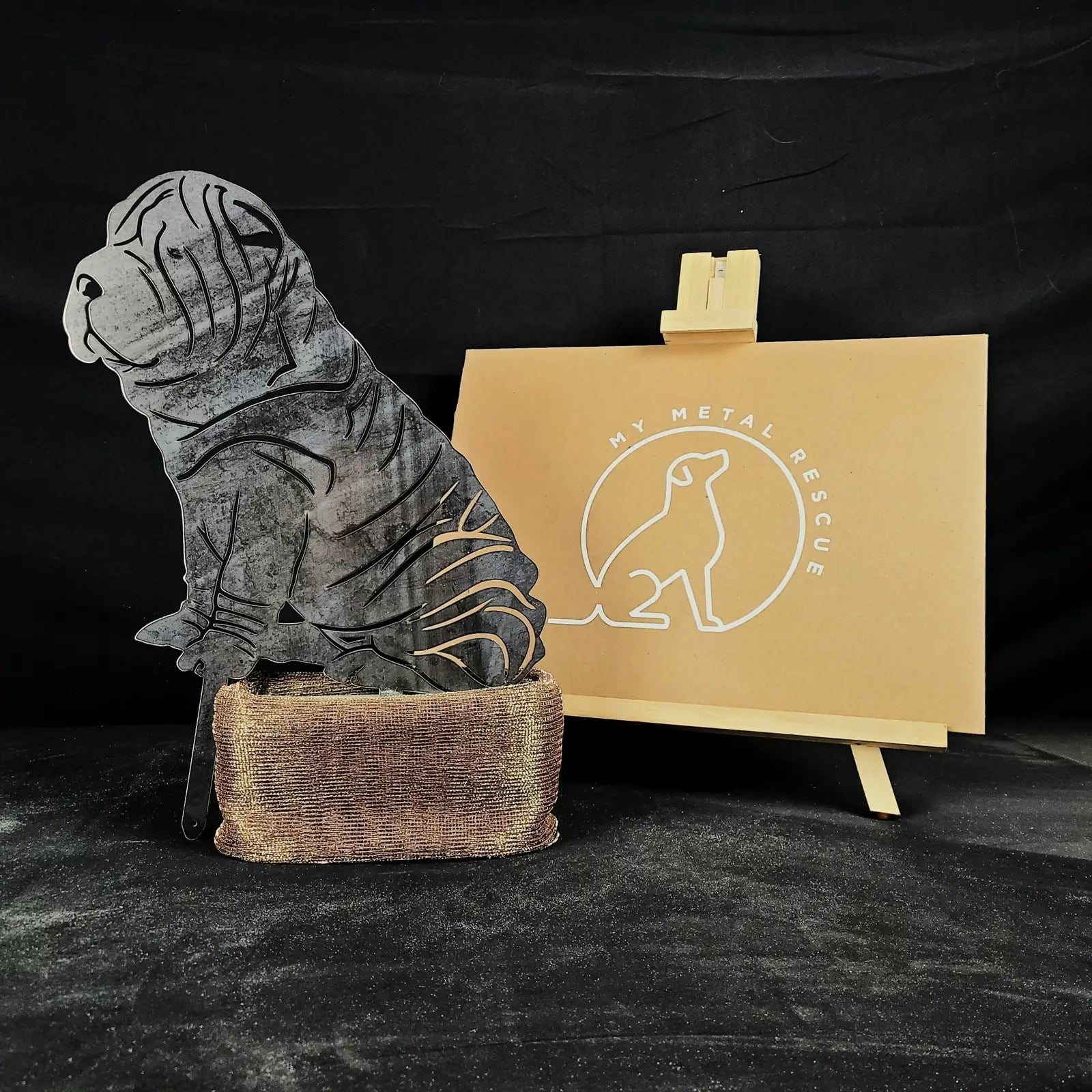 Shar Pei metal silhouette in weathered Corten steel, sitting on a textured base, showcasing unique dog breed art.