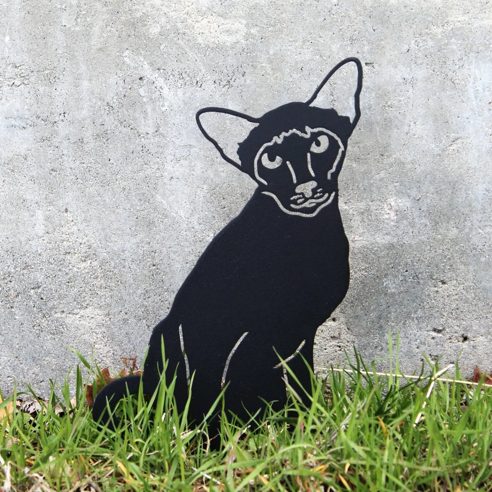 Black Siamese cat metal silhouette standing in grass, showcasing intricate detailing for garden decor.