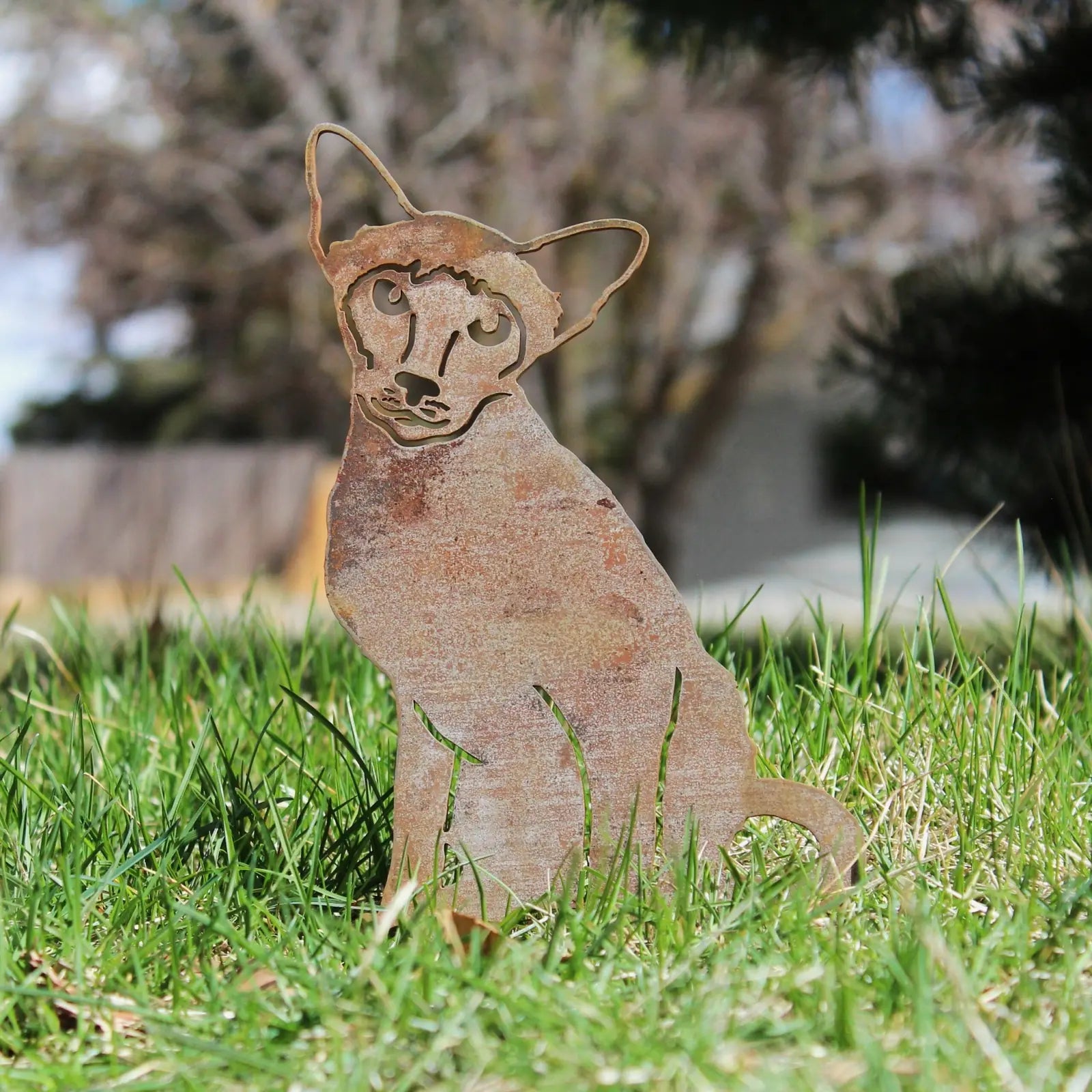 Siamese cat silhouette in rusty Corten steel, set in lush green grass, adding charm to outdoor decor.