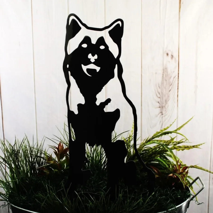 Siberian Husky metal silhouette in matte black, displayed among greenery, showcasing durable outdoor dog decor.