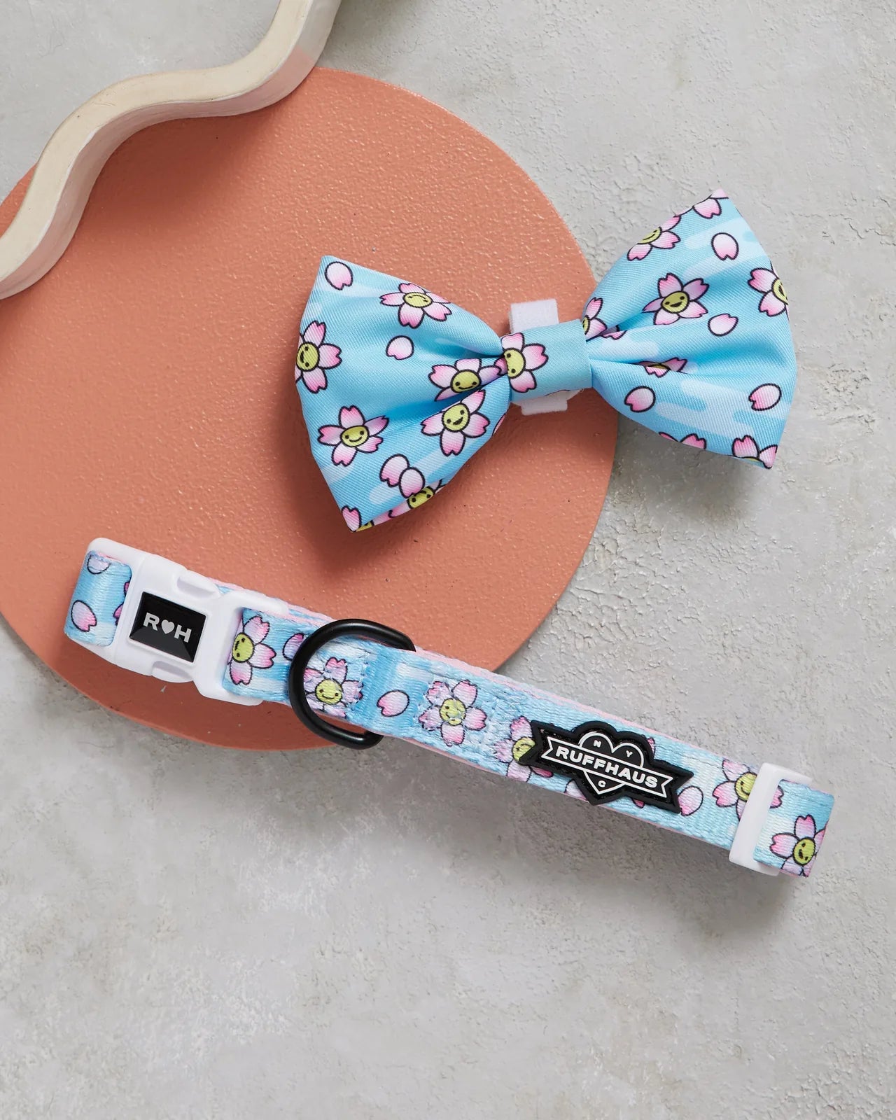 Adjustable blue dog collar with flower pattern and matching bowtie, featuring soft neoprene lining and durable materials.