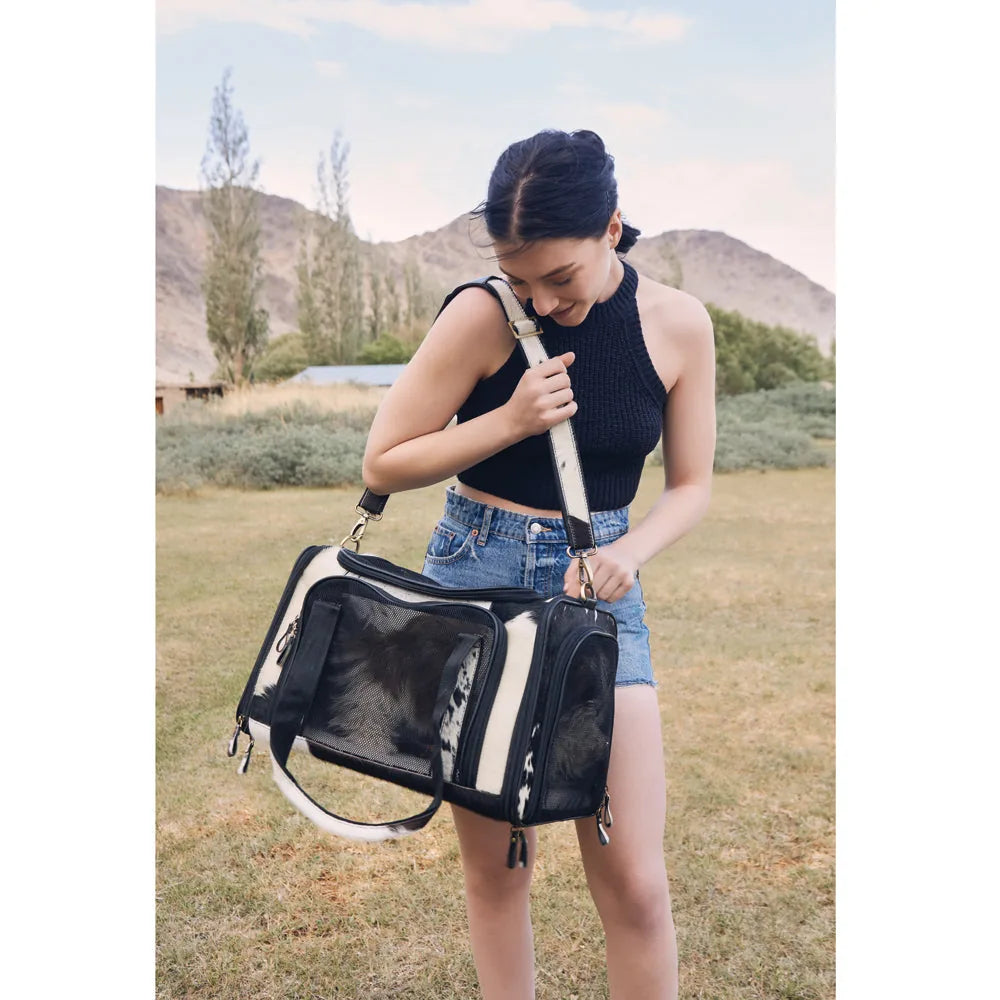Stylish Smoke Hairon Leather Dog Bag in black and white, being held by a woman in an outdoor setting.