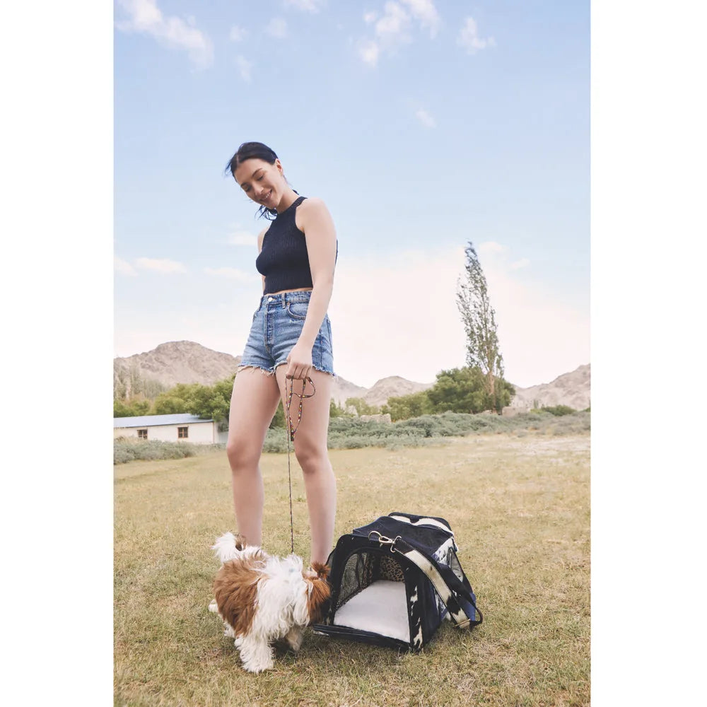 Smoke Hairon Leather Dog Bag beside a woman in shorts, with a small dog exploring outdoors.