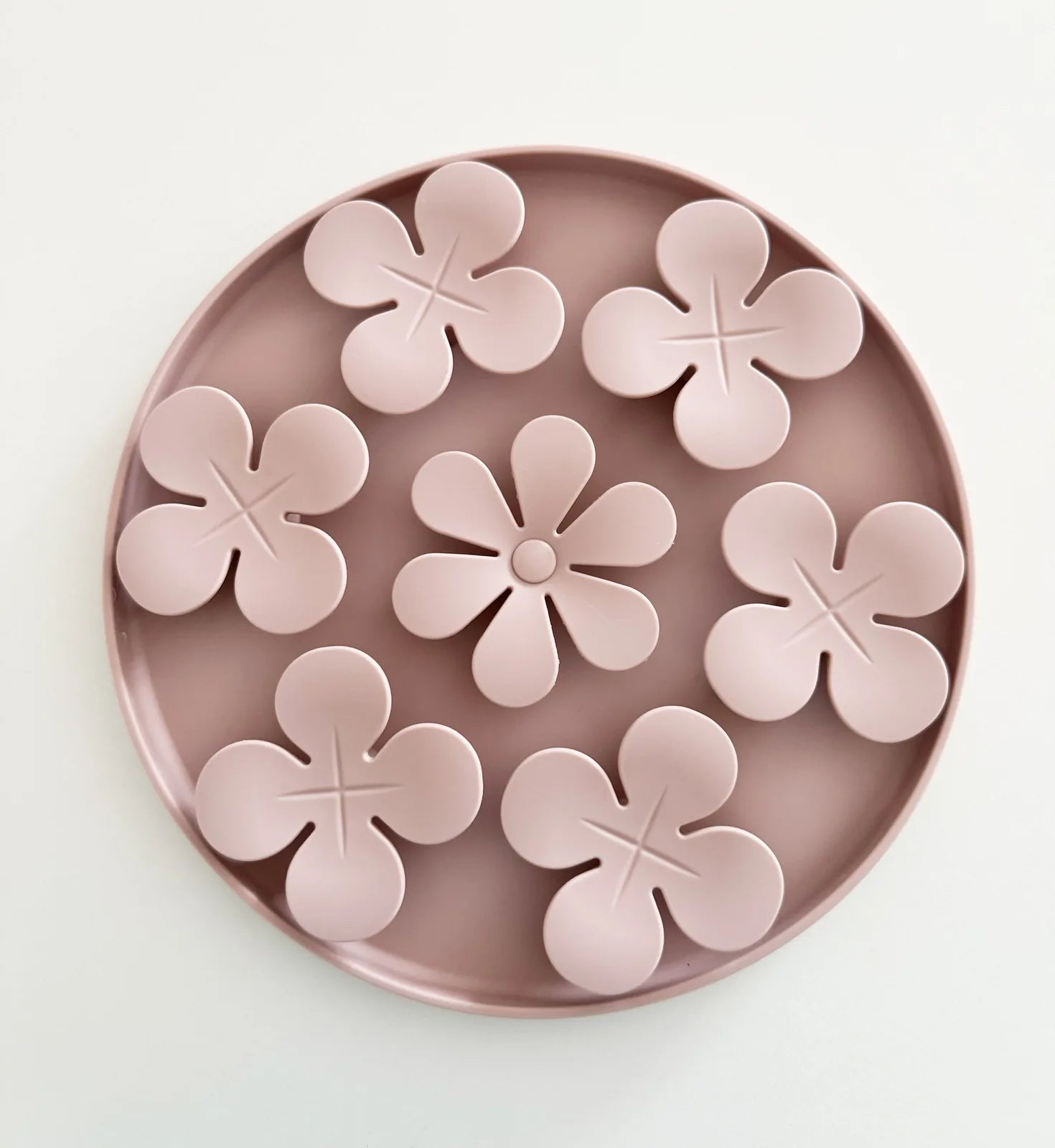 Snuffle mat in soft pink, featuring flower-shaped compartments for hiding treats and encouraging foraging.