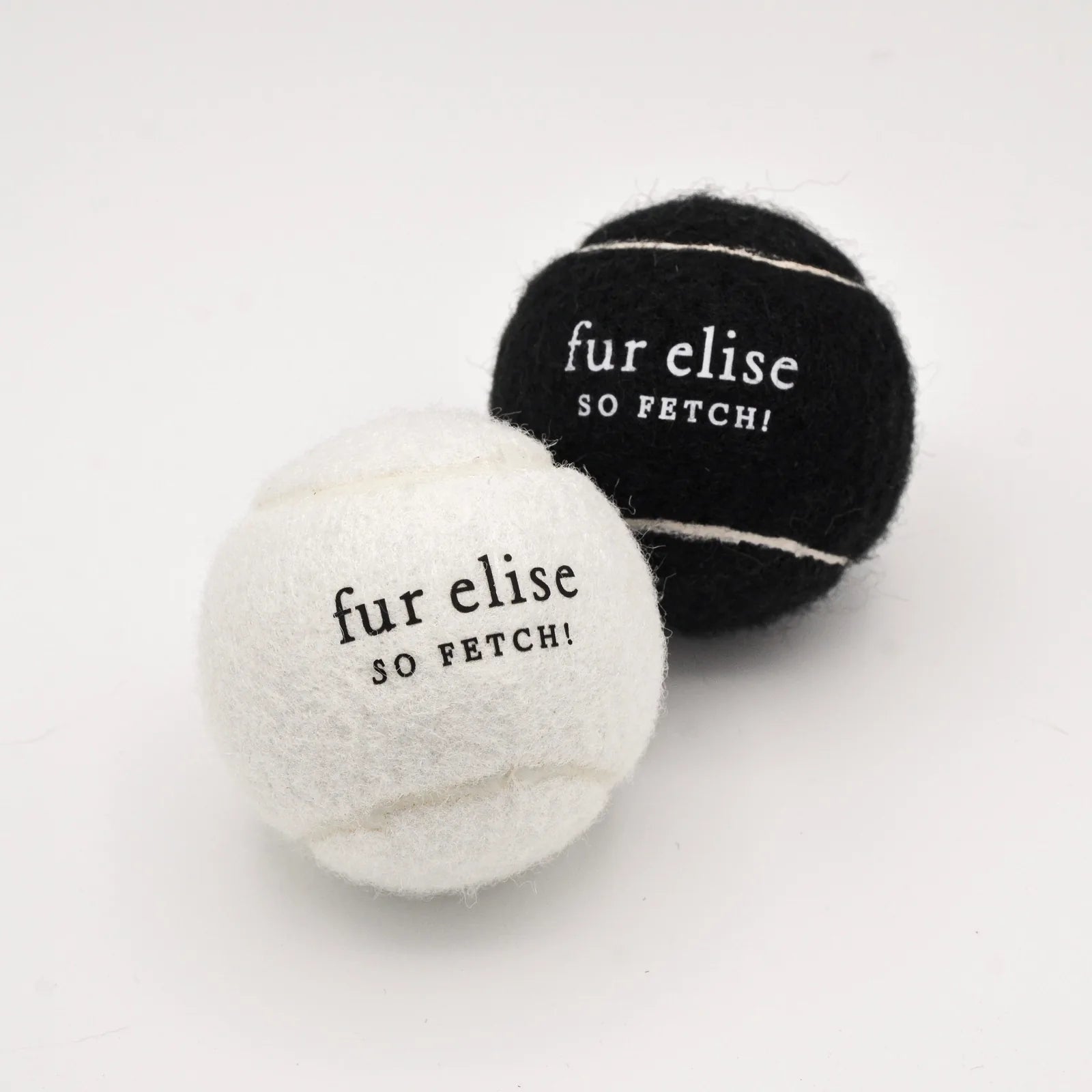 Stylish black and white tennis balls for dogs, featuring "fur elise" and "SO FETCH!" text, made of pet-safe felt.