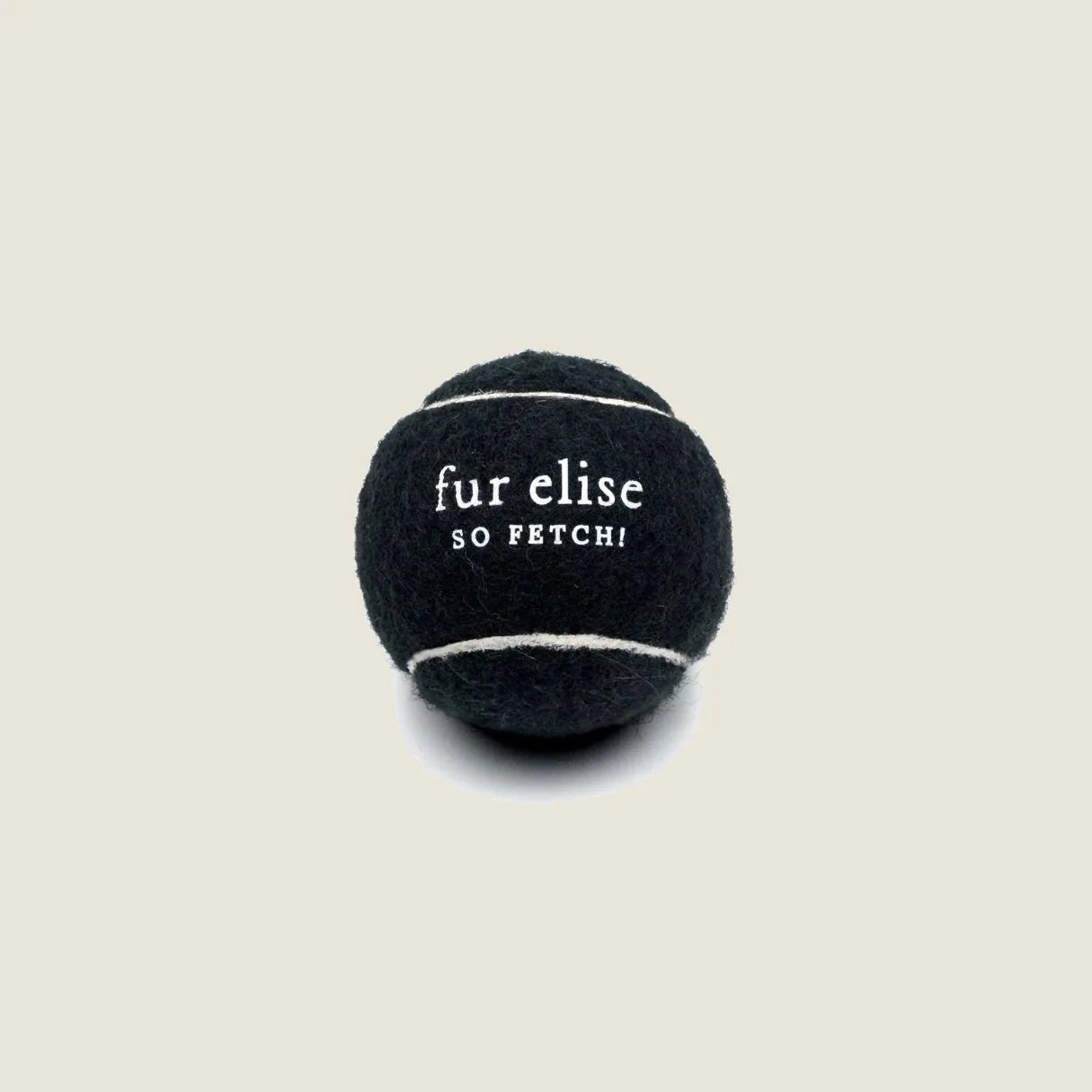 Black tennis ball with white stitching, featuring "fur elise" and "SO FETCH!" text, designed for dog play.