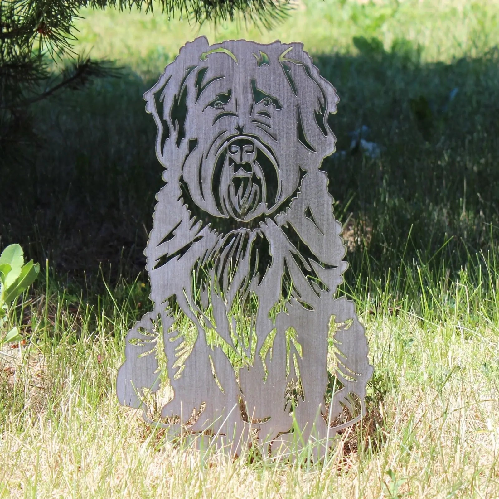 Soft Coated Wheaten Terrier metal silhouette in weathering steel, set against grassy outdoor backdrop.
