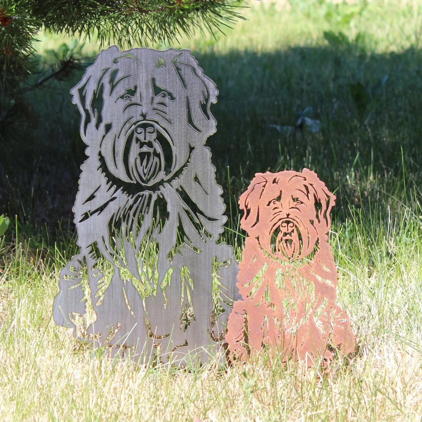 Soft Coated Wheaten Terrier metal silhouettes in Corten steel and a natural rust finish, set in green grass.