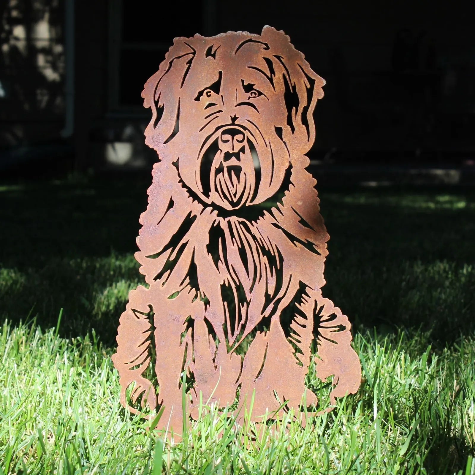 Corten steel silhouette of a Soft Coated Wheaten Terrier, showcasing intricate details in a garden setting.