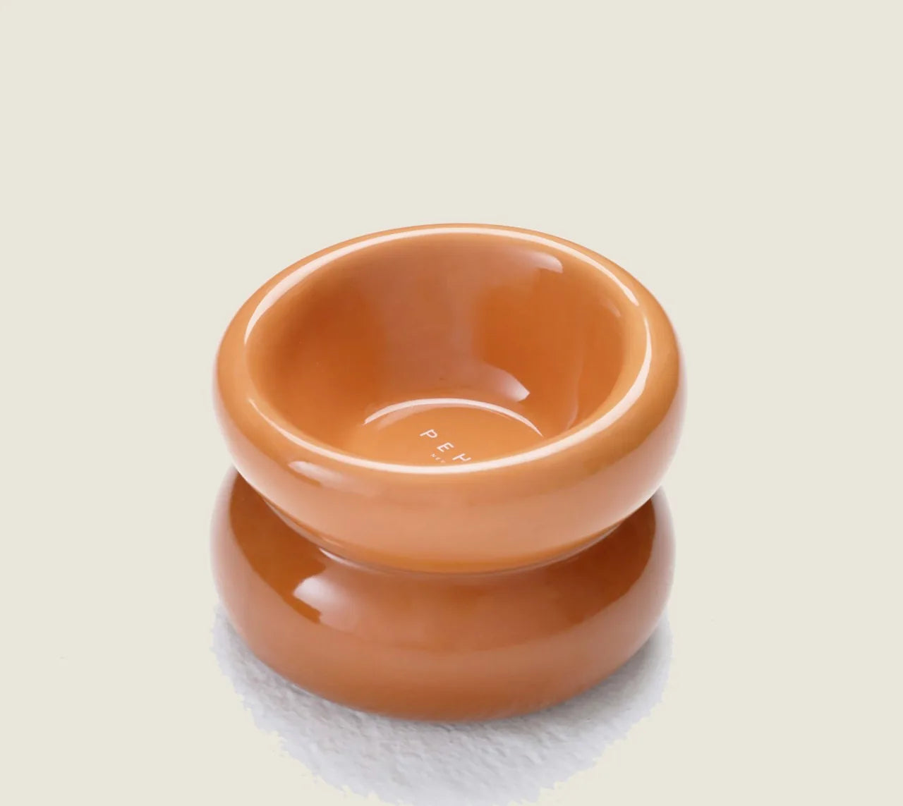 Amber orange pet bowl with a smooth finish and diagonal opening, designed for comfortable feeding.