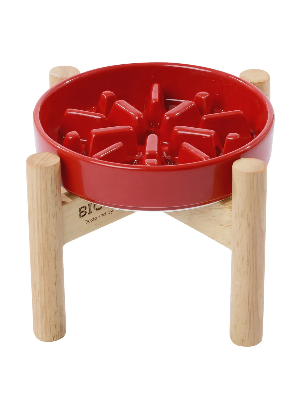 Red slow feeder dog bowl with spikes, elevated by a natural wood stand, designed for better digestion and stable feeding.