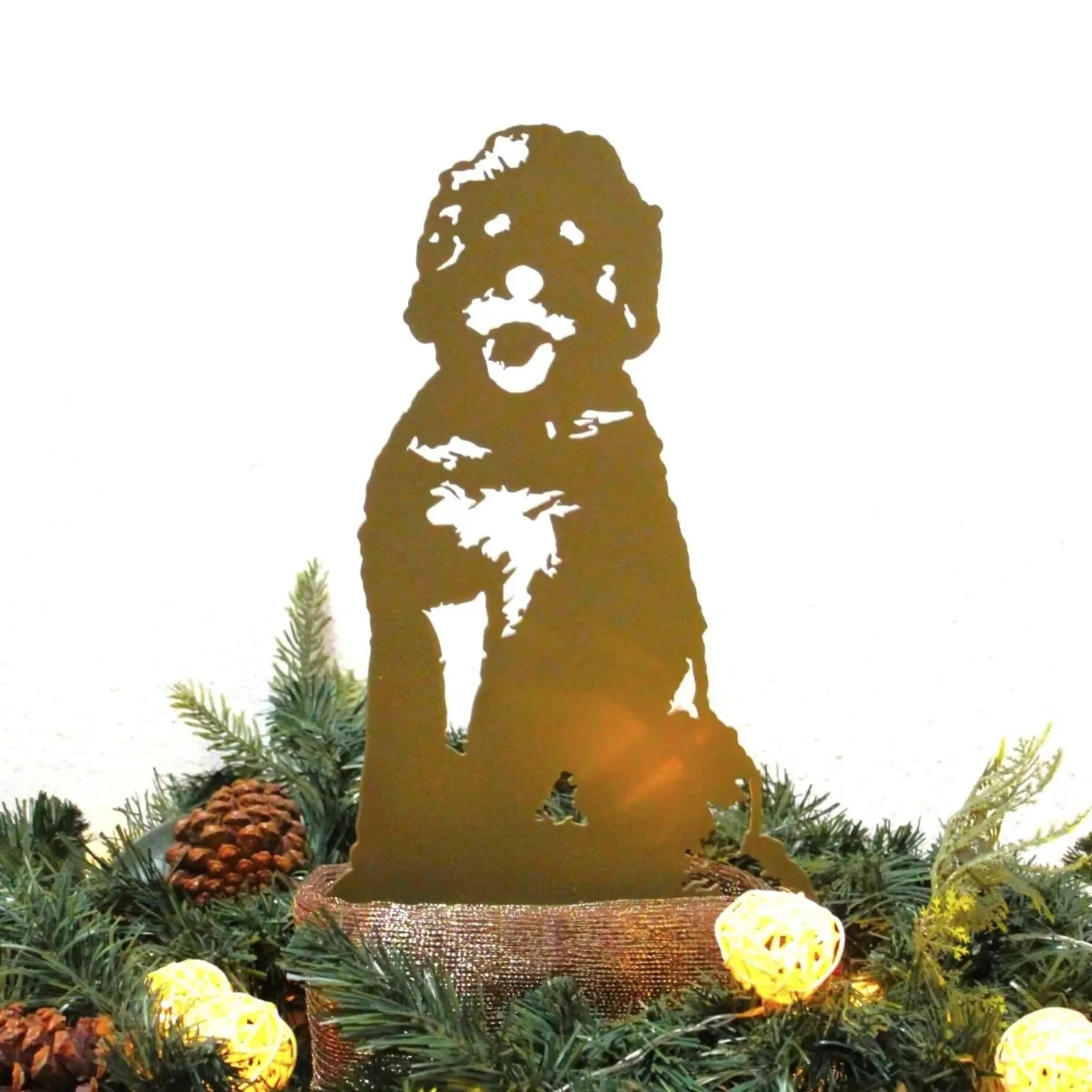 Gold Doodle metal silhouette standing among festive greenery and decorative lights, showcasing a metallic finish.