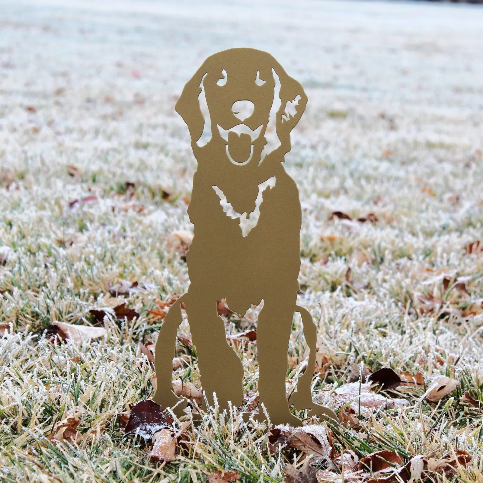 Gold metal silhouette of a sitting Golden Retriever on frosted grass, featuring a playful expression, ideal for outdoor de...