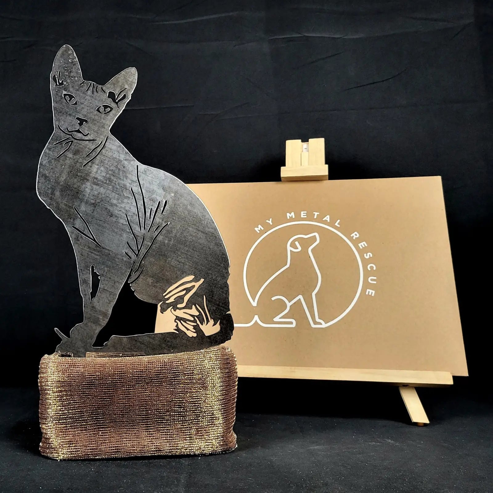 Sphynx silhouette metal garden art in Corten steel, showcasing intricate design against a dark background.