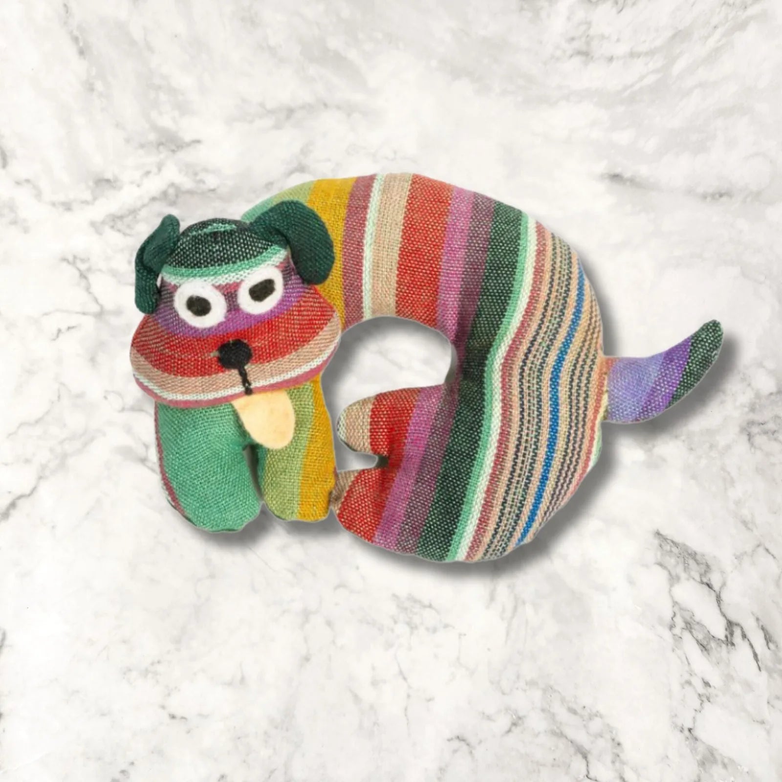 Colorful striped fabric dog-shaped trivet with a playful design, featuring a green and purple color palette.