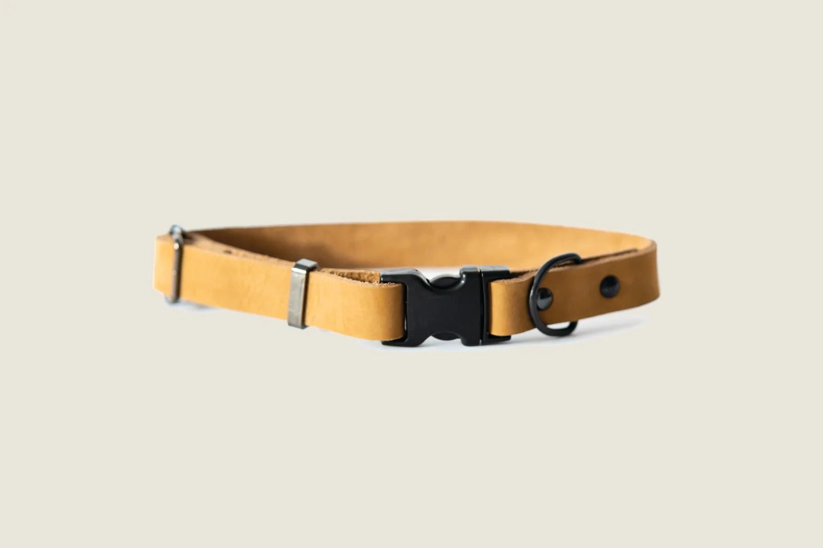 Khaki leather dog collar featuring a black quick-release buckle and hardware, designed for durability and comfort.