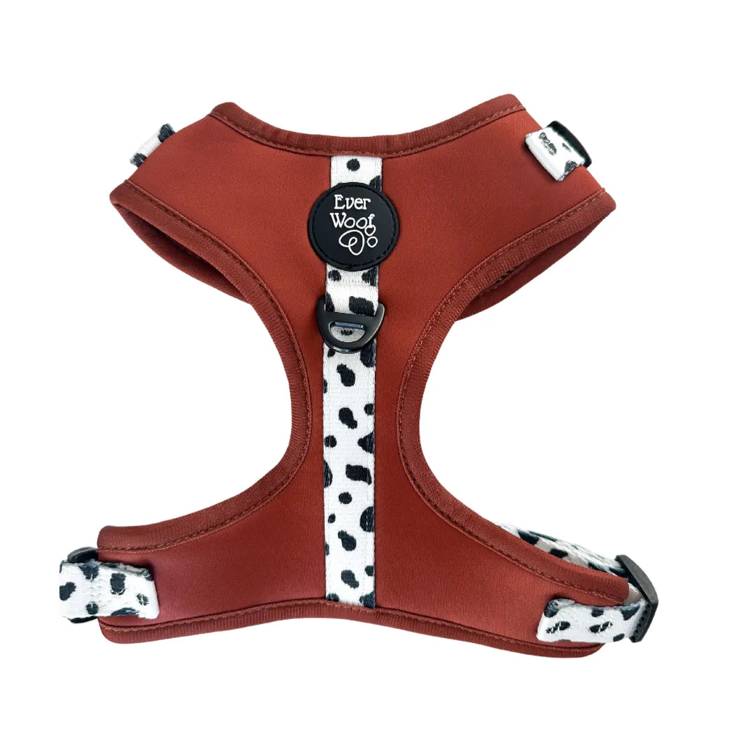 Burnt orange adjustable harness with black and white spotted straps, featuring a breathable neoprene material for comfort.