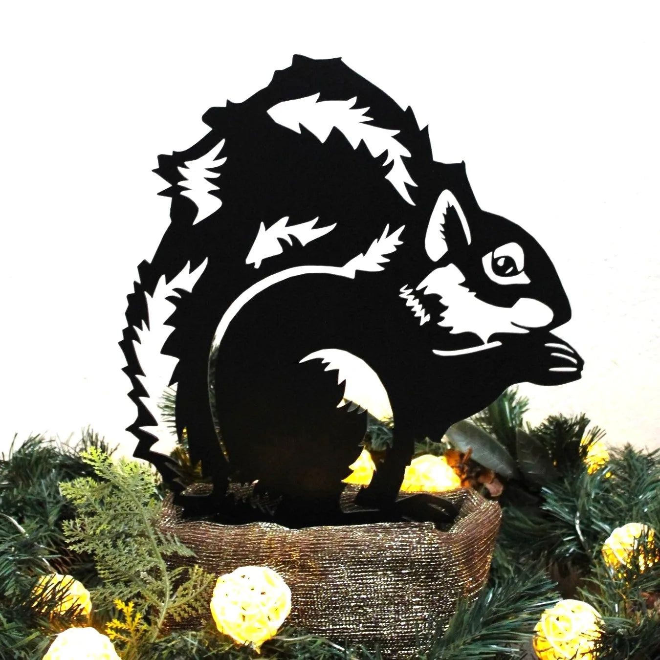 Black metal squirrel silhouette from My Metal Rescue, showcased among greenery and decorative lights.