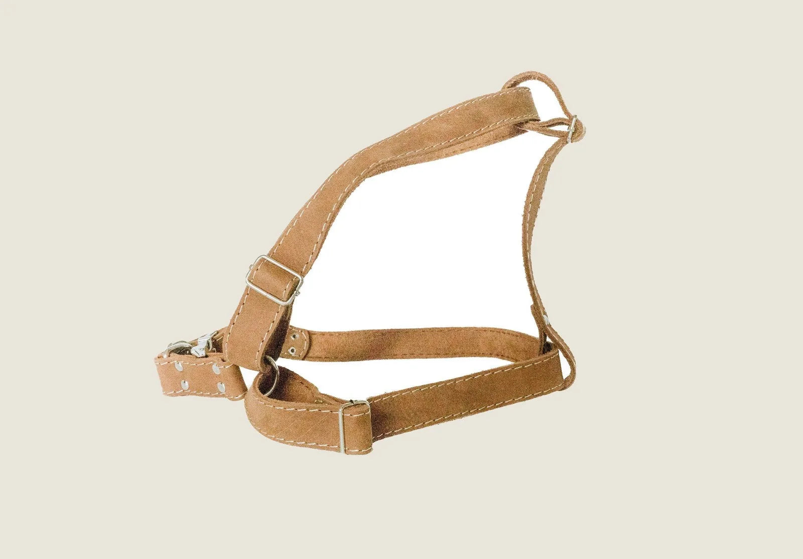 Tan leather dog harness with a simple design and adjustable straps for comfort and style.
