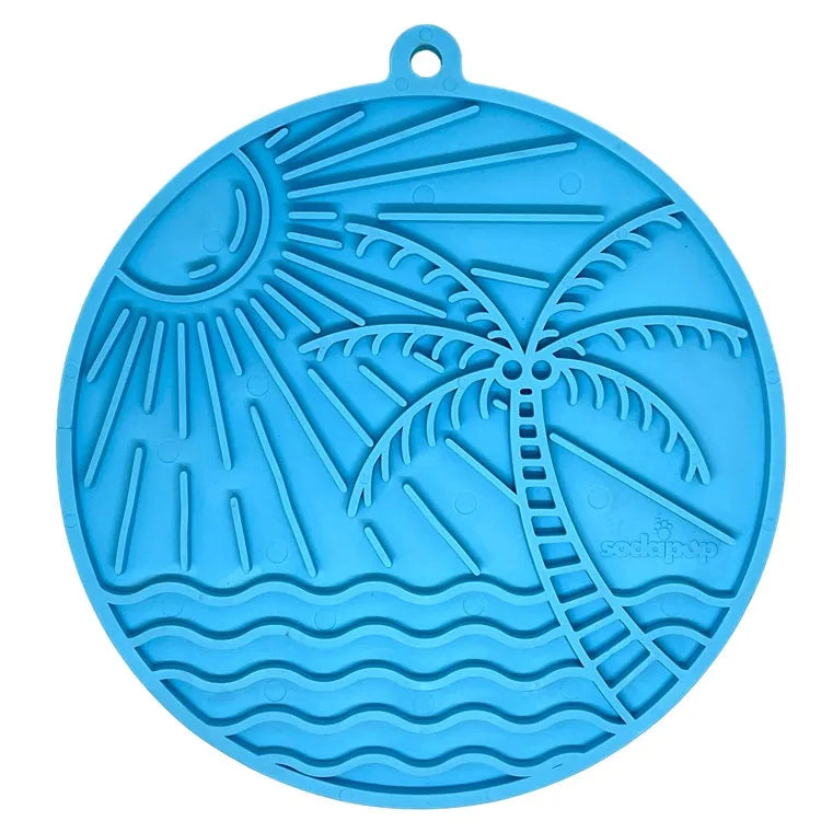Beach-themed blue enrichment lick mat featuring a sun, palm tree, and wave patterns, designed for dogs and cats.