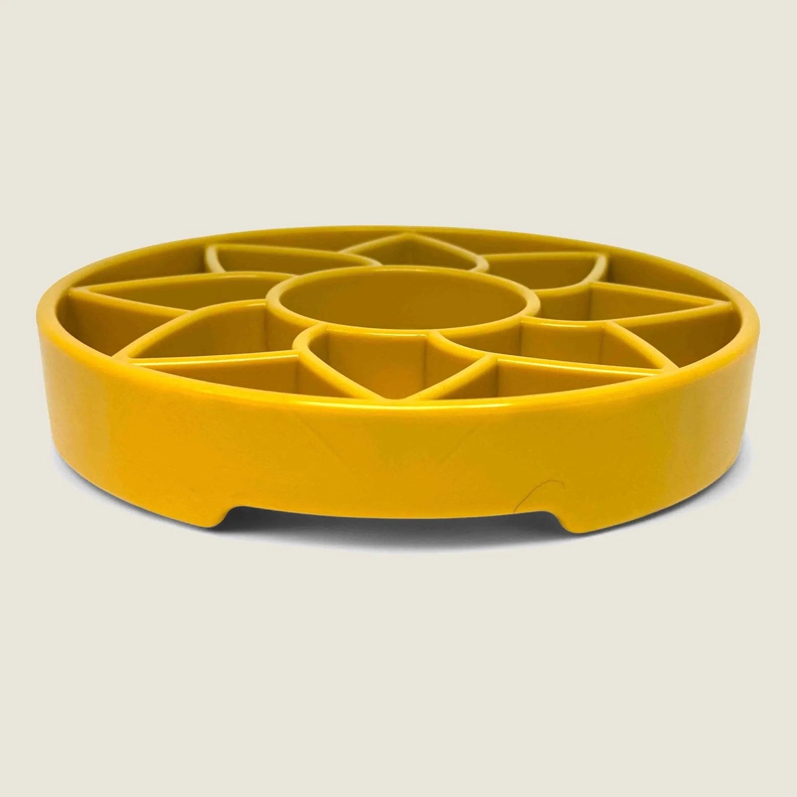 Yellow sunflower-shaped slow feeder dog bowl with shallow design and raised patterns for enrichment.