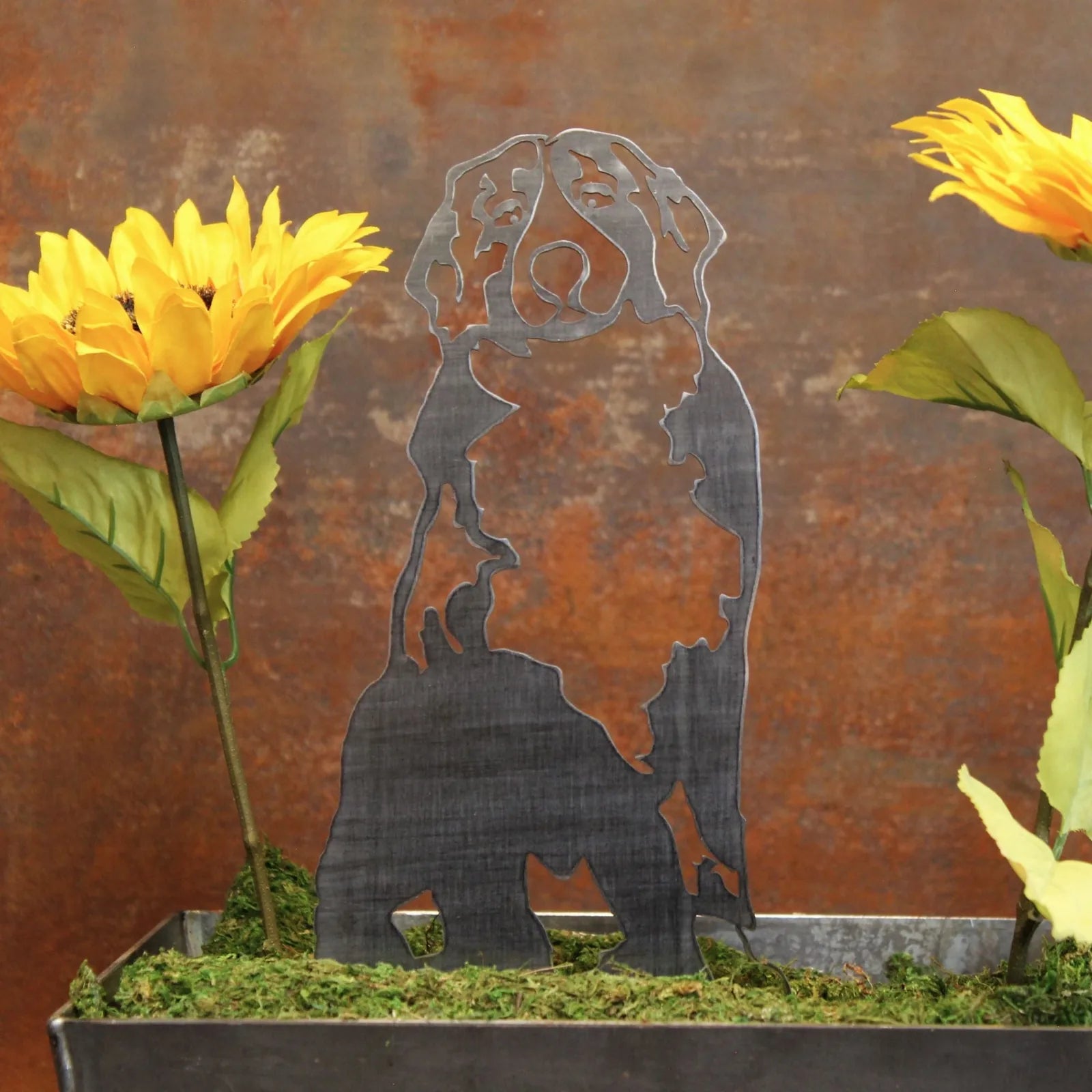 Swiss Mountain Dog metal silhouette in black, surrounded by sunflowers and greenery, on a rustic backdrop.