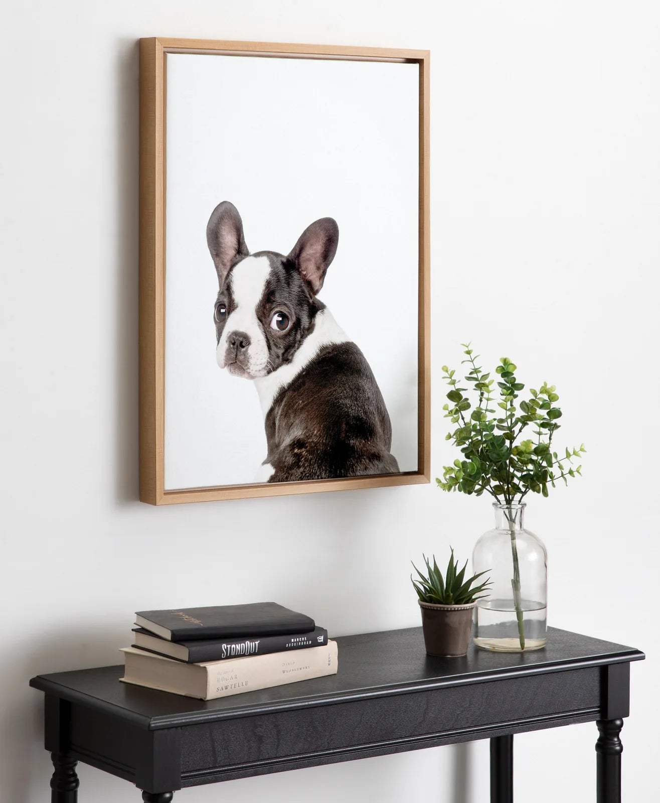 Framed canvas art featuring a playful French Bulldog illustration, set against a light background and displayed on a black...
