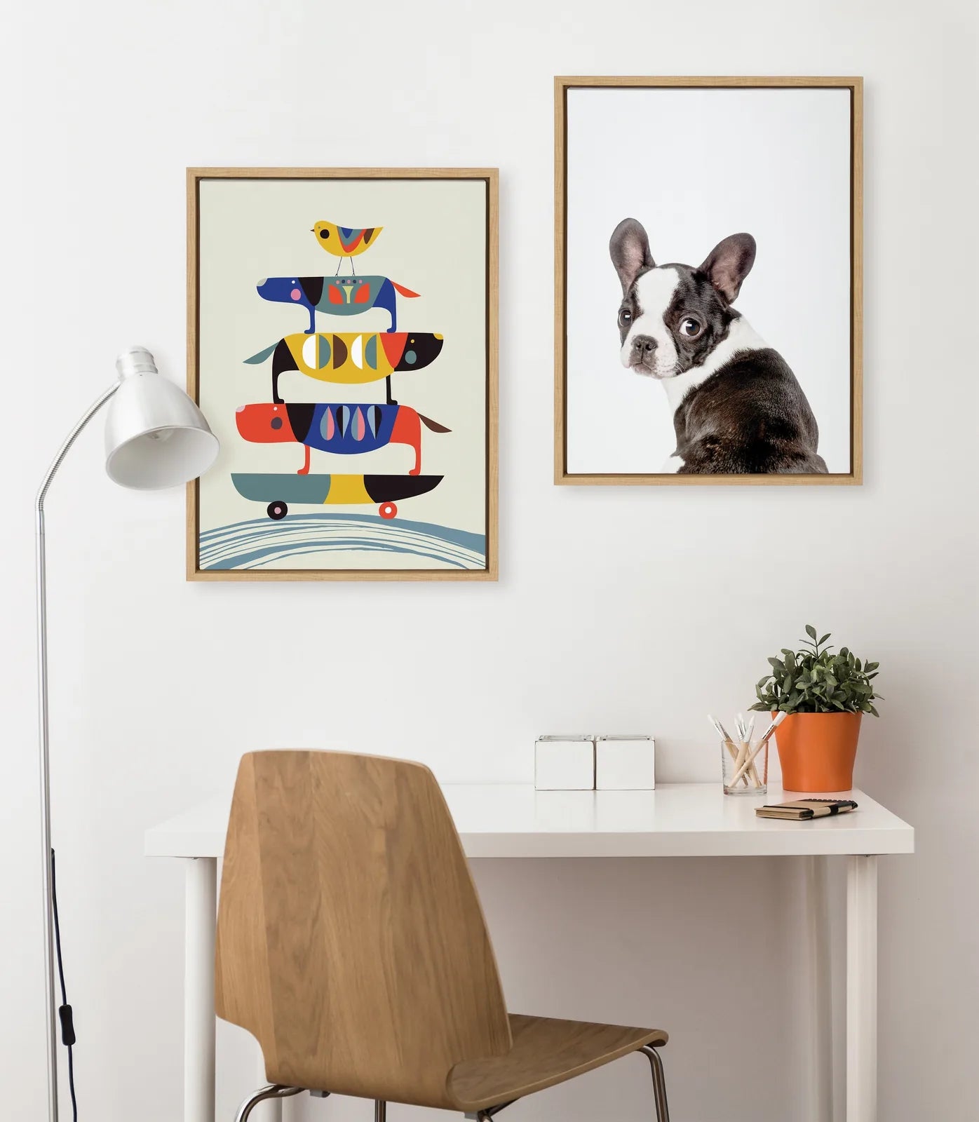 Framed canvas featuring a French Bulldog illustration by Amy Peterson, displayed on a modern white desk.