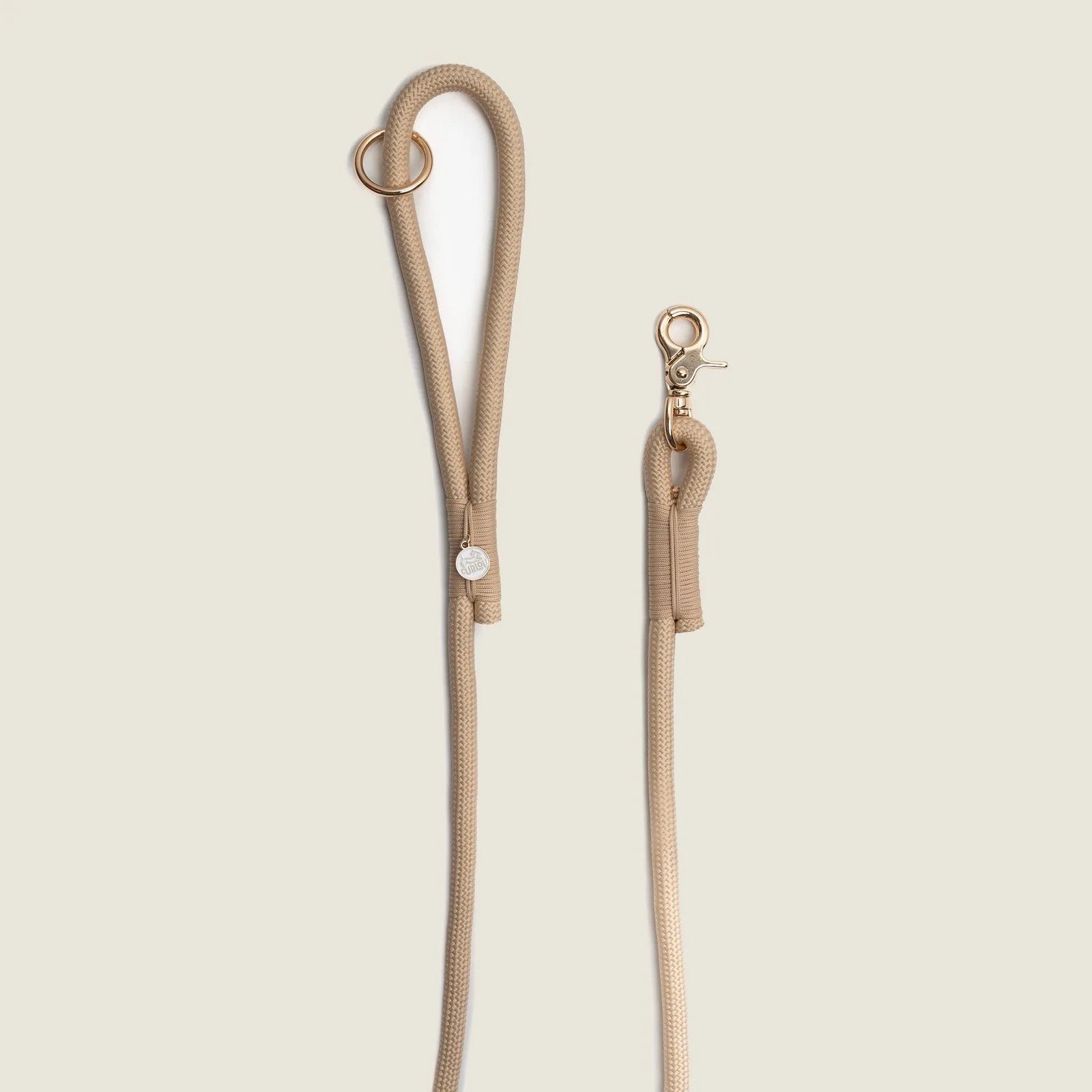 Tan braided rope leash with a gold O-ring and clip, designed for comfort and durability during dog walks.