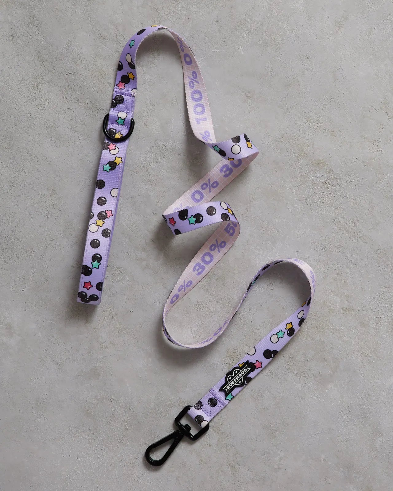 Lavender dog leash with playful patterns of black and colorful shapes, featuring a sturdy swivel snap clasp.
