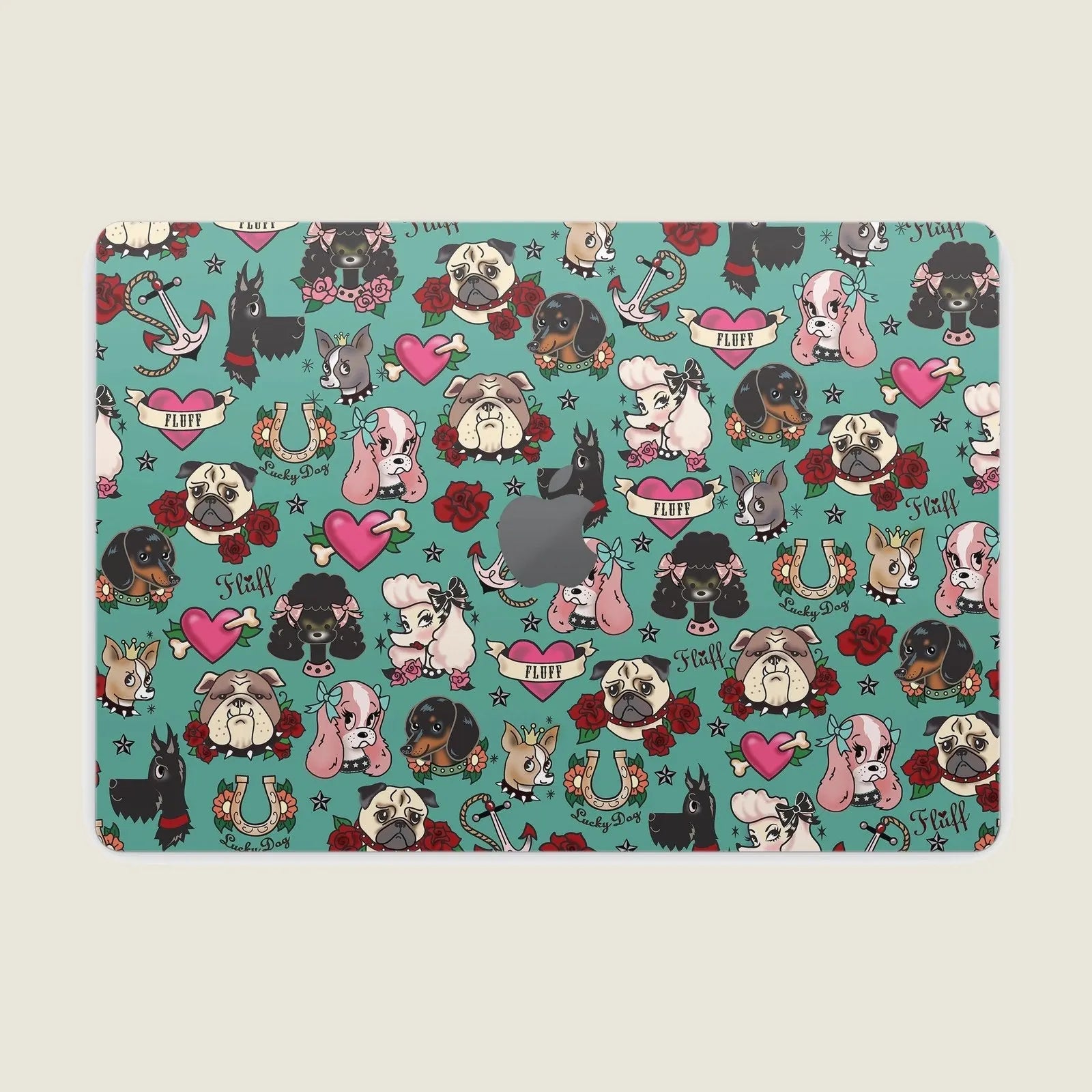 Colorful Tattoo Dogs design on a teal MacBook skin, featuring various dog breeds, hearts, and floral accents.