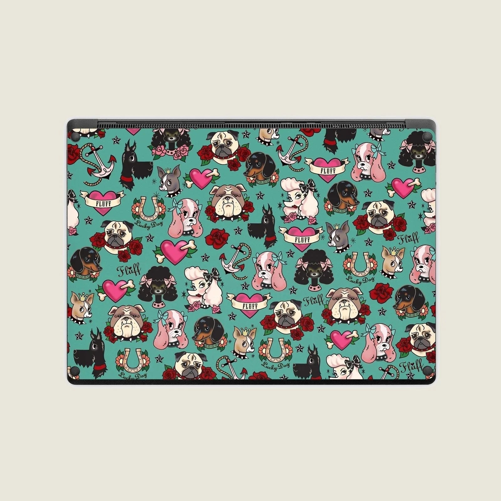 Vibrantly patterned laptop skin featuring various cartoon dogs, hearts, roses, and anchors on a teal background.