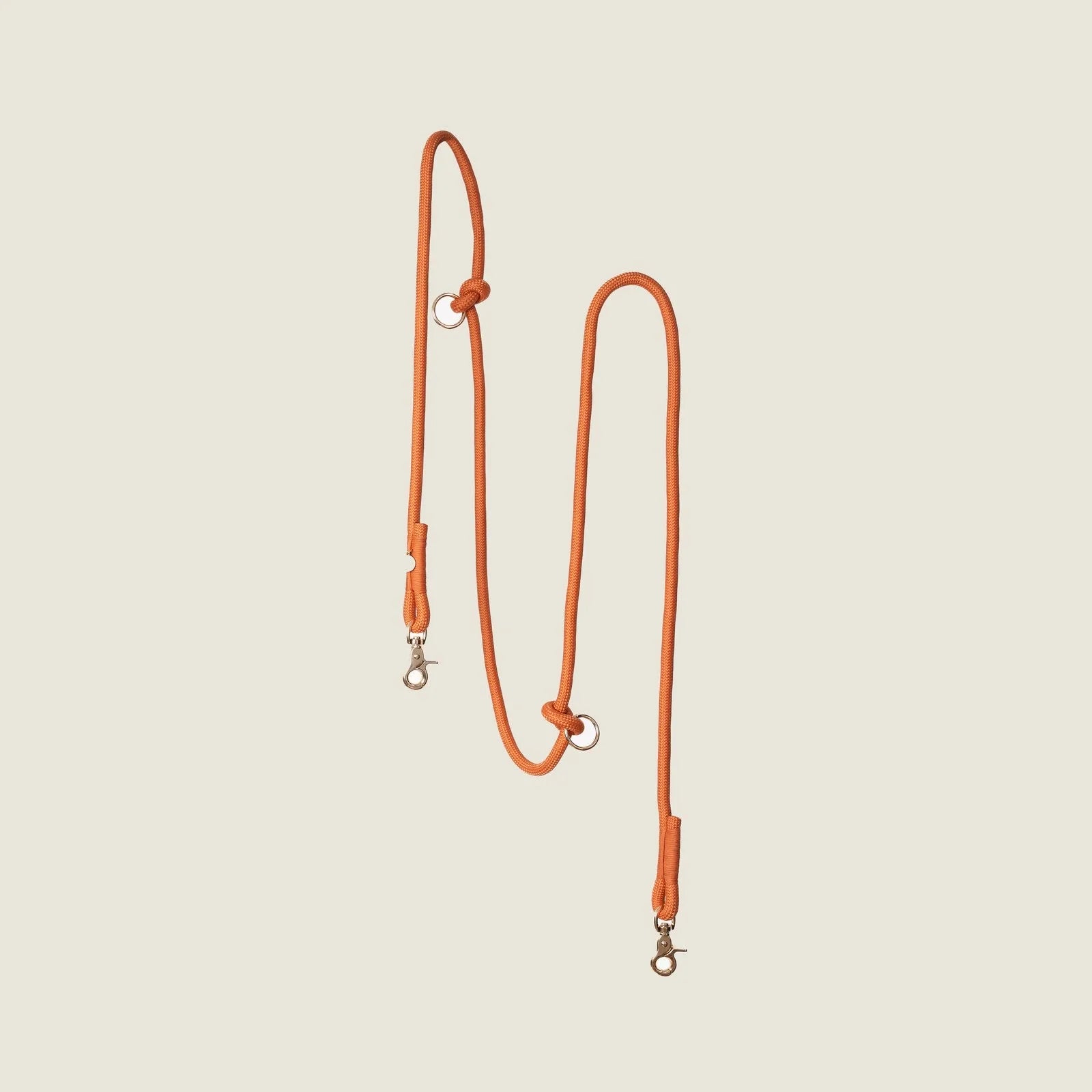 Hands-free braided leash in terracotta orange with metal clips for attachment, ideal for walking your dog.