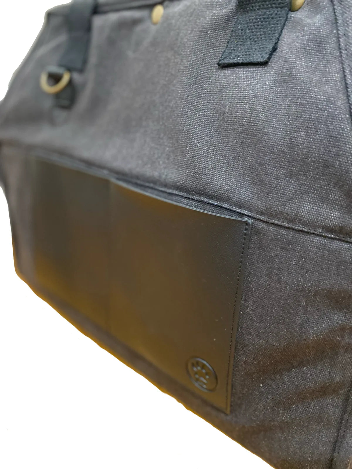 Stylish black pet carrier made from recycled cotton canvas with vegan leather trim, featuring a sleek side pocket.