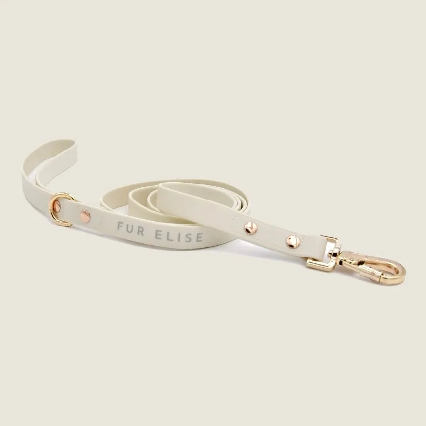 Lightweight cream leash featuring gold hardware, bold "FUR ELISE" lettering, and subtle rose gold accents.