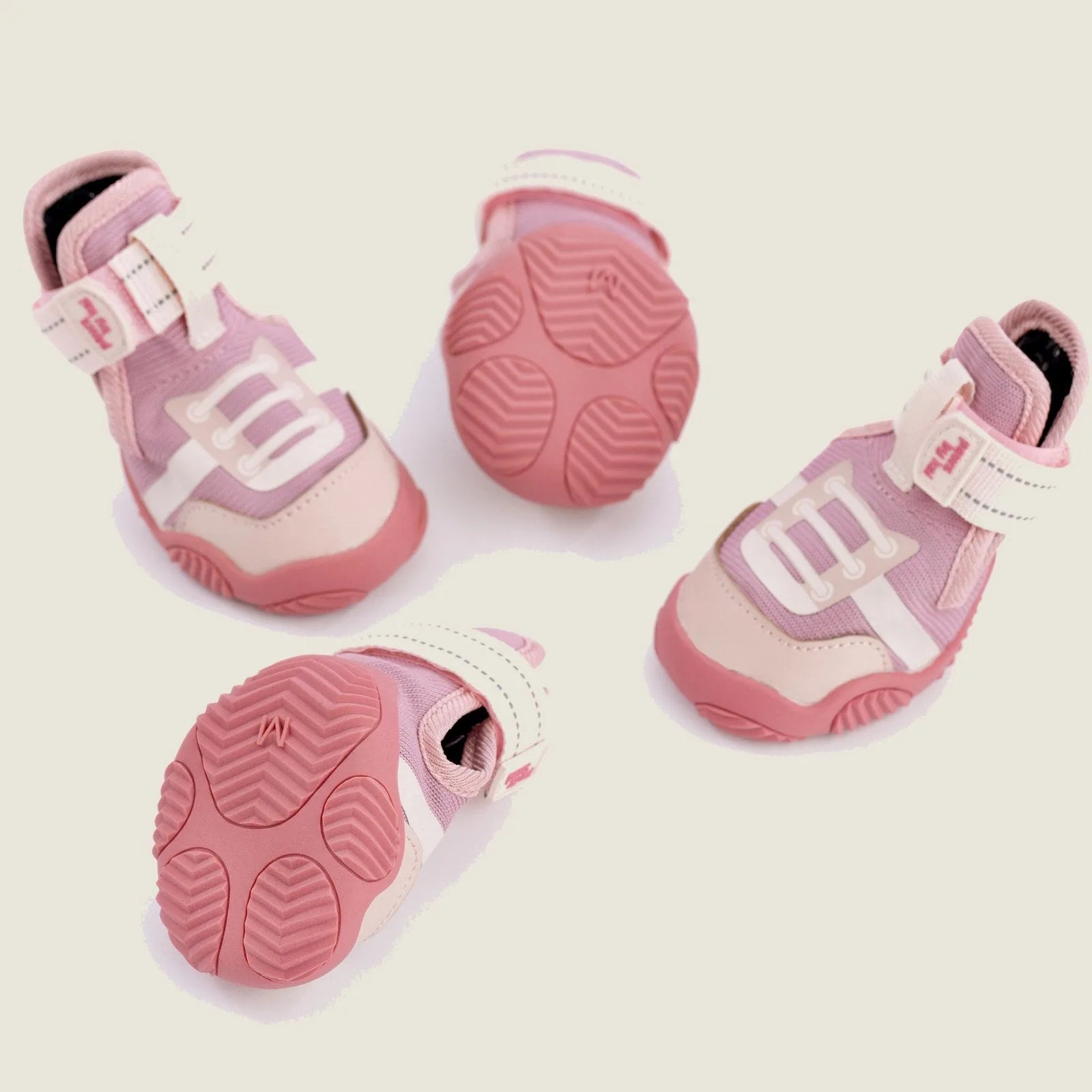 Pink dog sneakers featuring adjustable straps and grippy soles for comfort and support during outdoor activities.