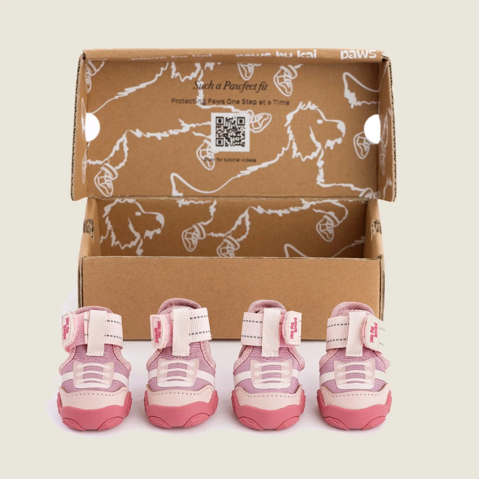 Pink dog sneakers by Paws By Kai in a box, featuring adjustable straps and durable soles for outdoor adventures.