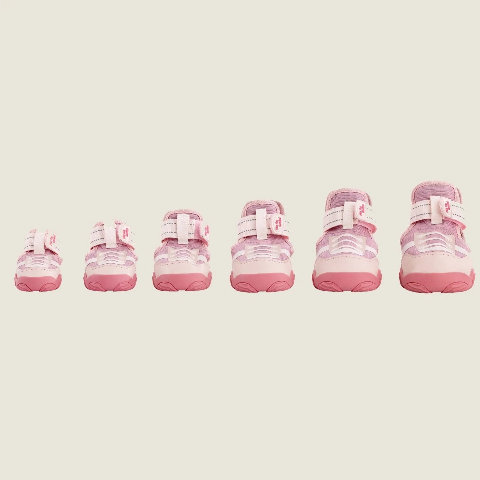 Pink dog sneakers in varying sizes with adjustable straps and durable soles, ideal for outdoor activities.