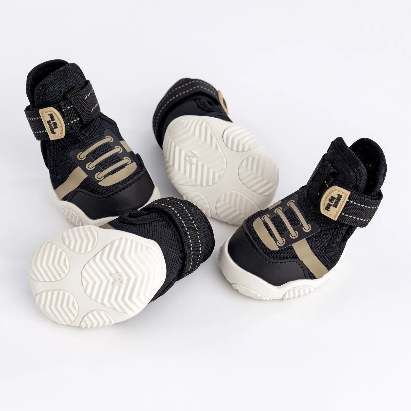 Black dog sneakers with adjustable straps and durable grippy soles, designed for outdoor activities.