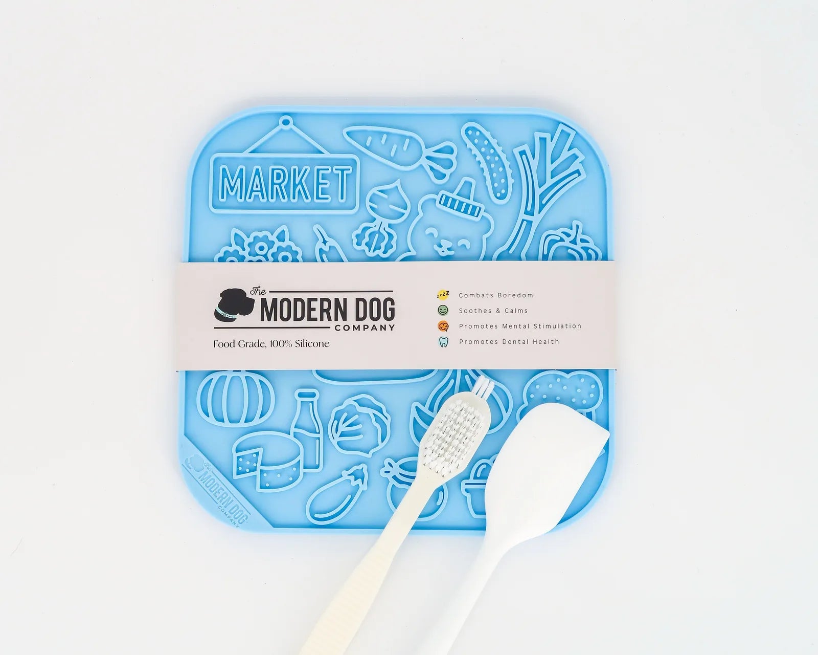 Colorful blue silicone lick mat with textured designs, spatula, and scrub brush for dog feeding and enrichment.