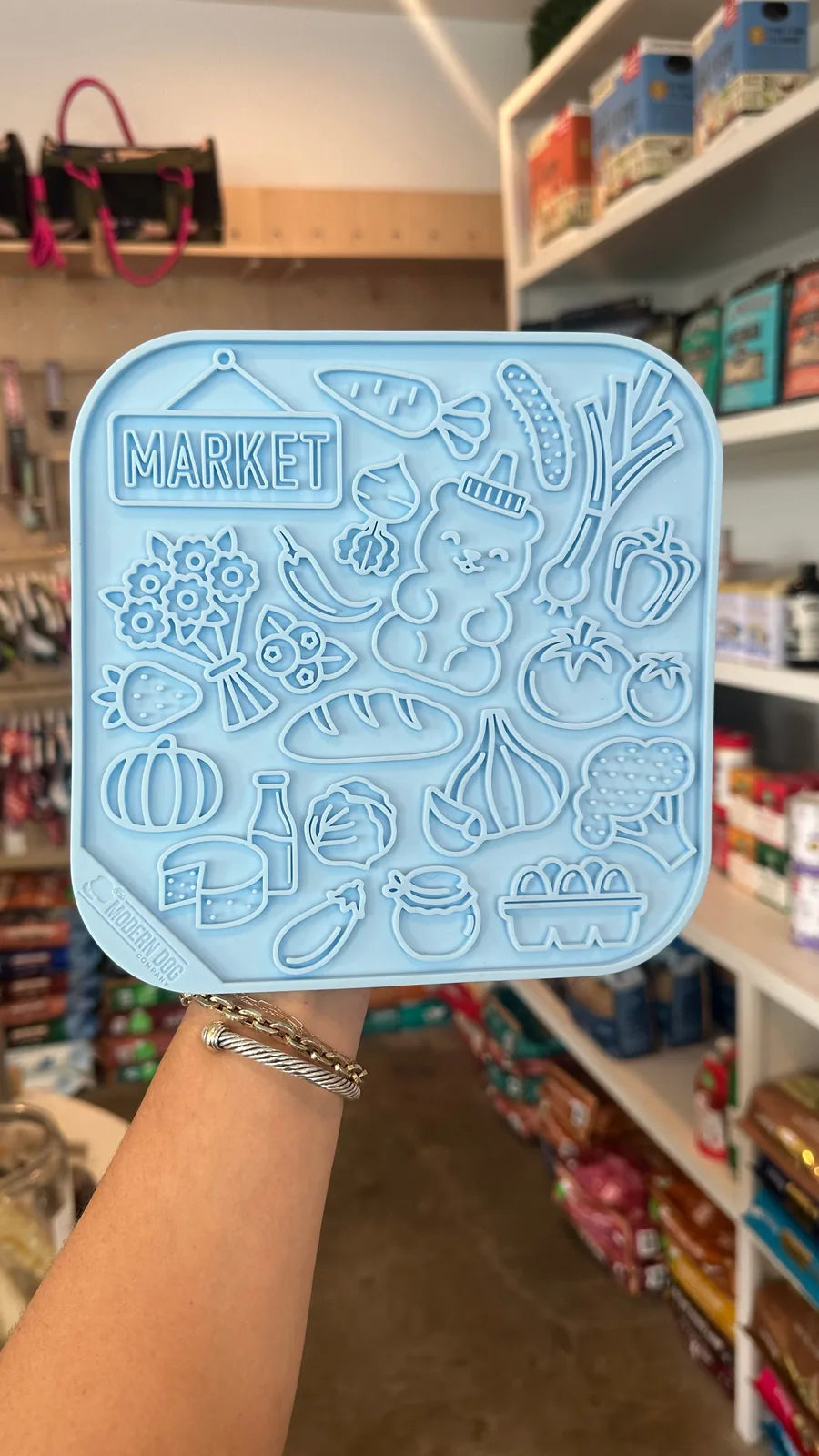 Colorful blue lick mat with a farmers market design featuring fruits, vegetables, and playful icons, made of food-grade si...