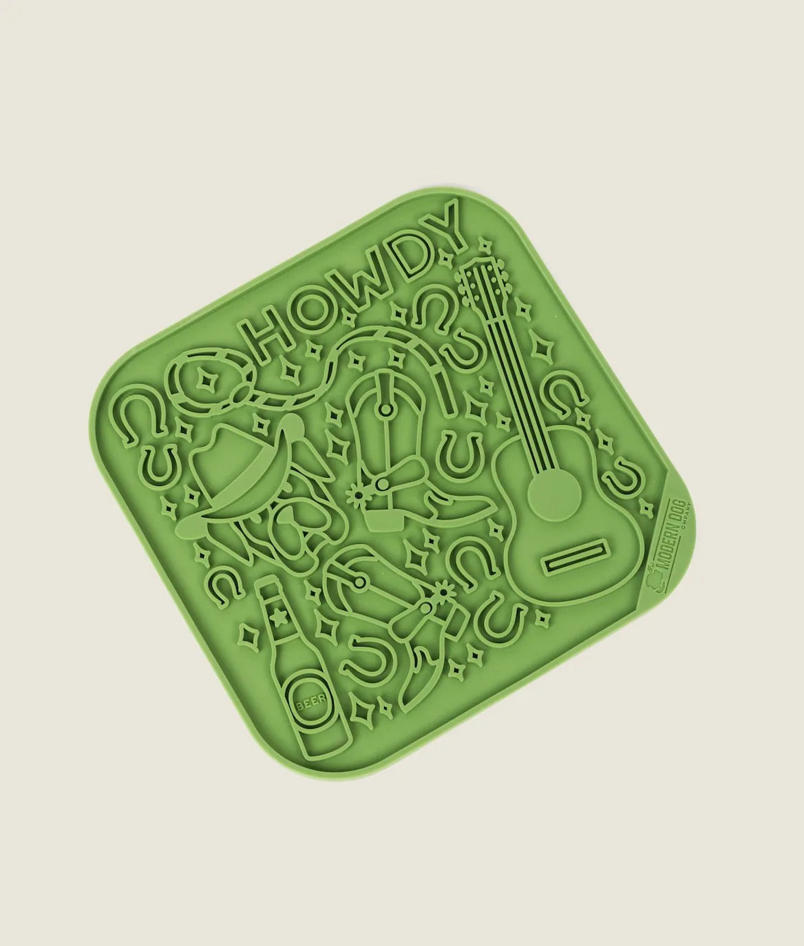 Bright green silicone lick mat with fun "Howdy" design, featuring a guitar, cowboy hat, and themed patterns for dogs.