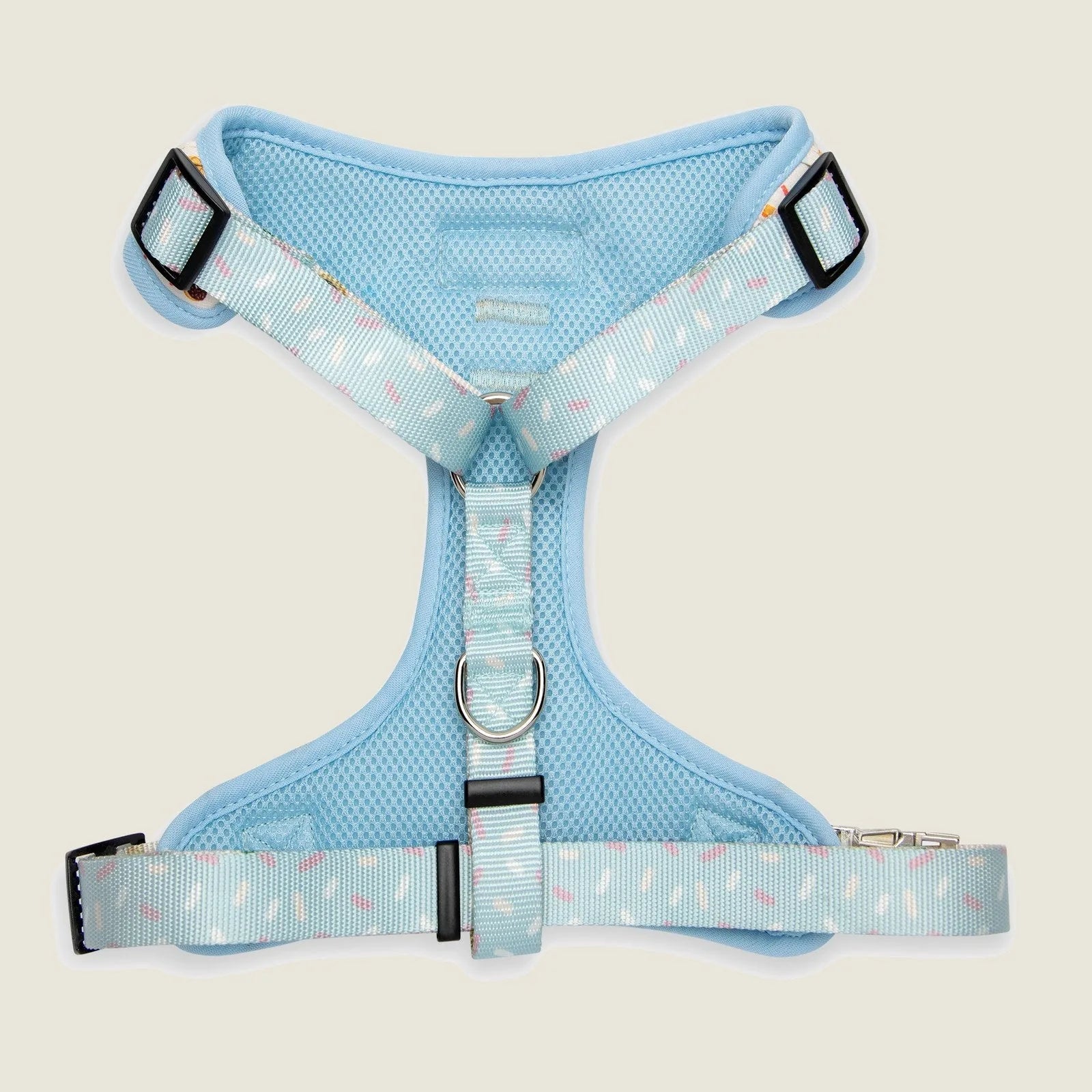Light blue dog harness featuring adjustable straps and playful patterns, designed for everyday walks.