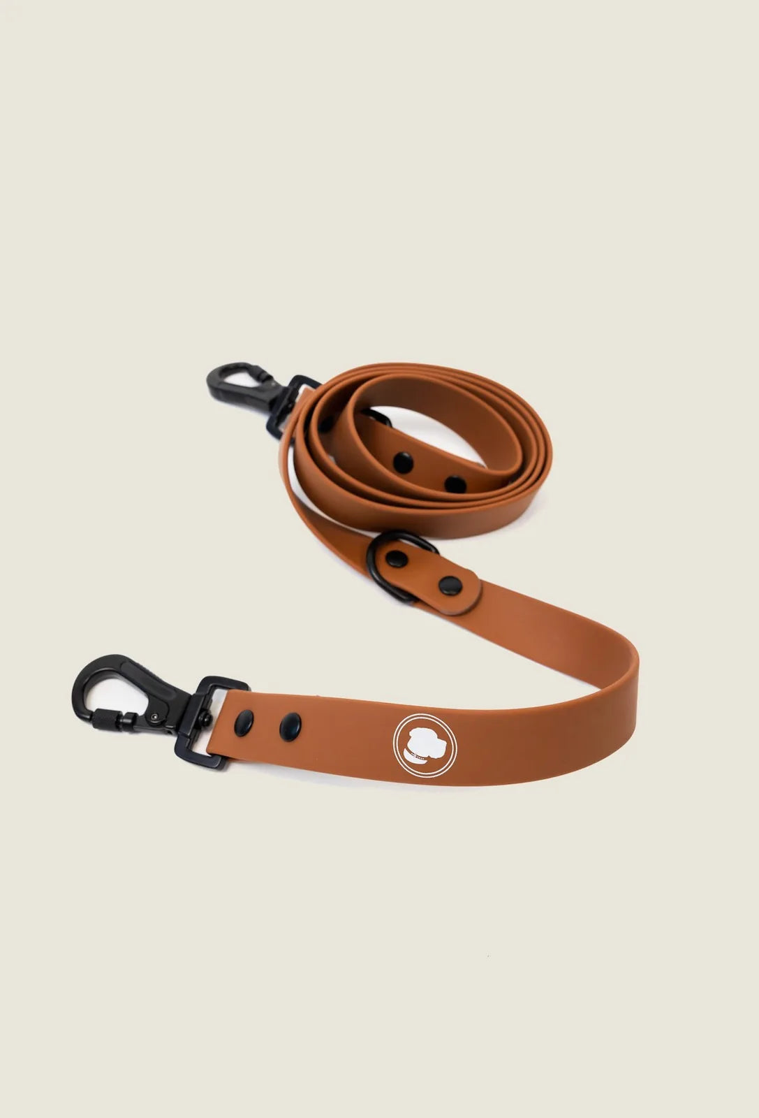 Coco brown adjustable dog leash with black clips, featuring an easy-to-clean all-weather design and logo emblem.