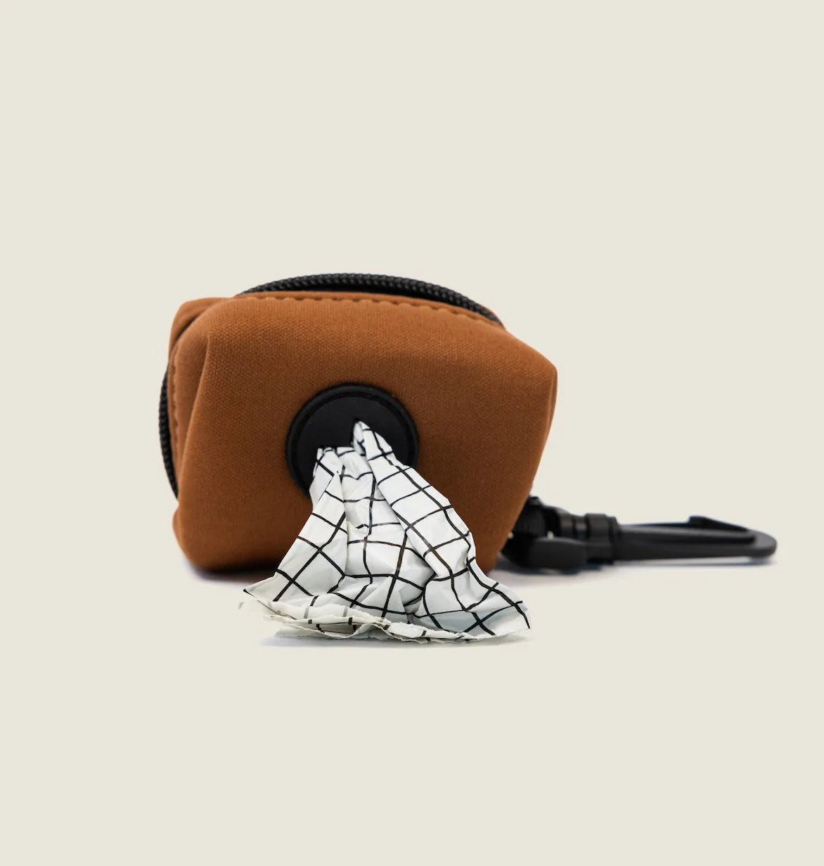 Compact brown neoprene dog waste bag holder with white checkered bag visible, designed for easy leash attachment.