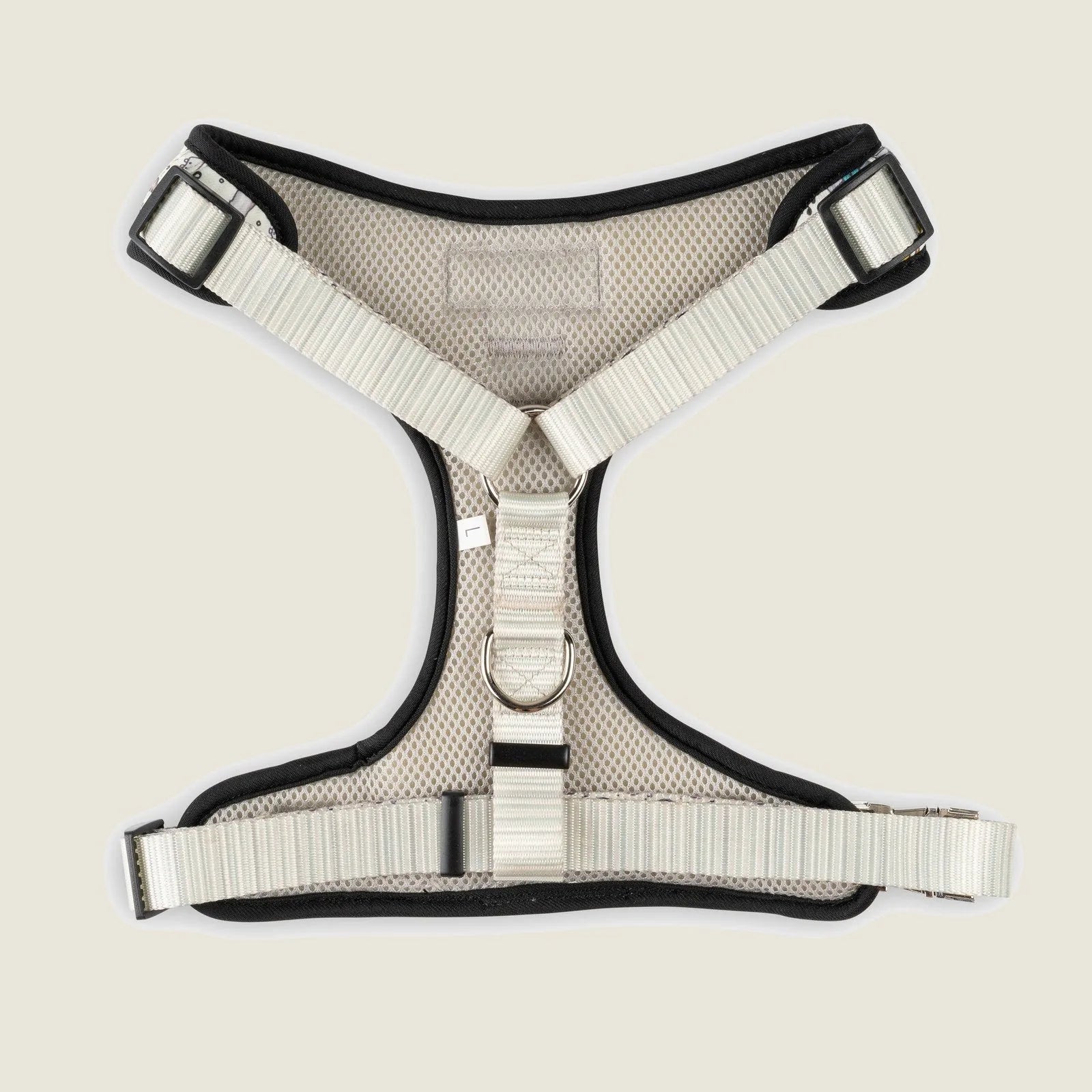 Beige mesh dog harness with adjustable straps and double D-ring design for safe leash attachment.